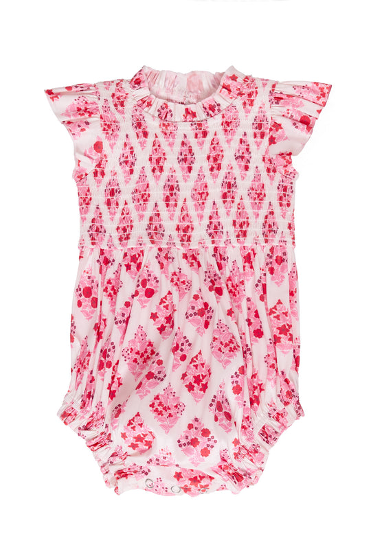 Pink and white patterned baby romper on a white background