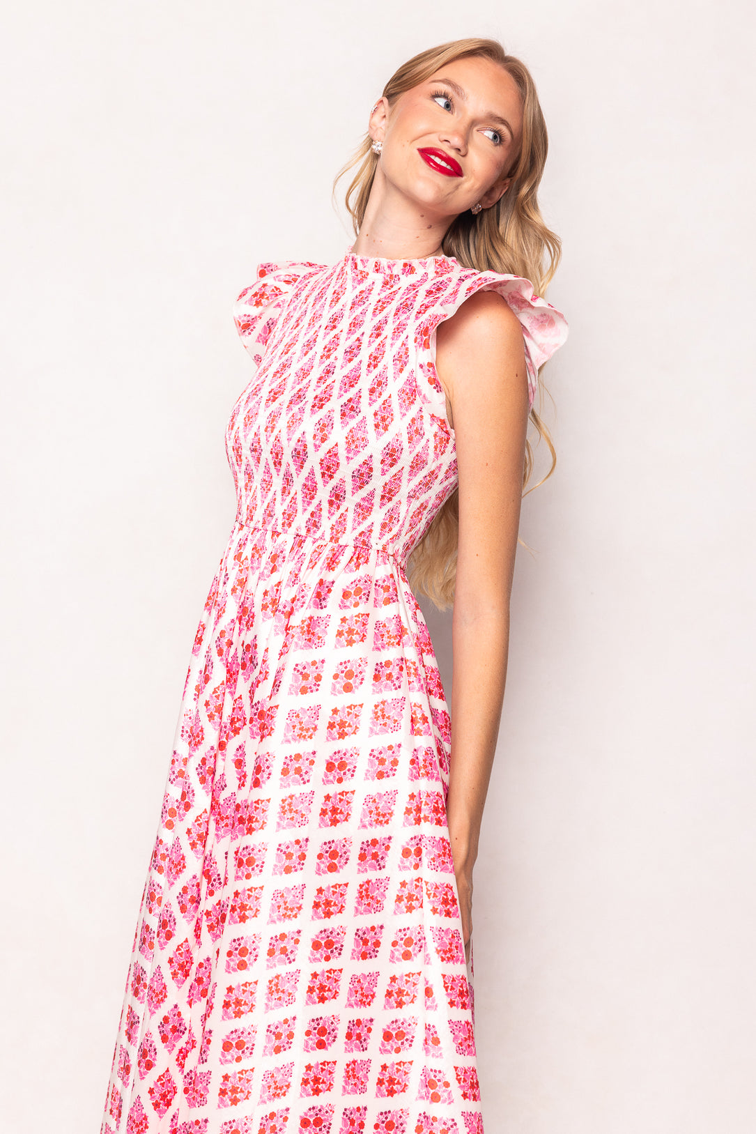 Woman wearing a pink floral dress against a white background