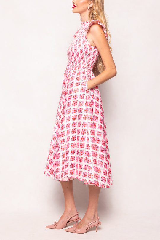 Woman wearing a pink and white patterned dress against a white background