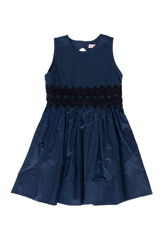 The Mini Greyson Dress in Navy by Ivy City Co features a sleeveless design with a round neckline, a fitted bodice accented by delicate black lace at the waist, and a flared skirt. Crafted from shiny fabric, this dress offers an elegant finish.