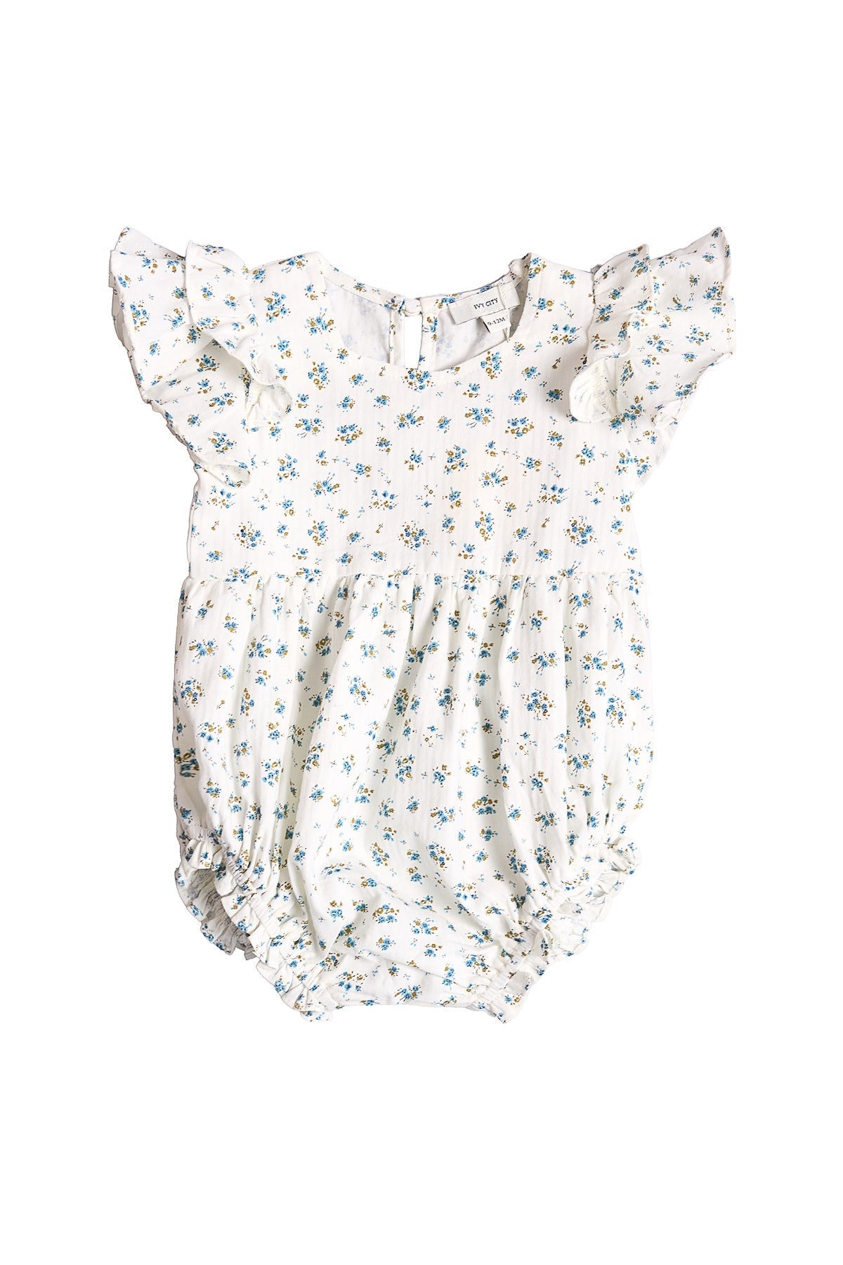 The Ivy City Co Baby Hattie Romper in Madeline Blue is an adorable white cotton baby romper adorned with a delicate blue floral print. It features short ruffle sleeves, a gathered waist, and elastic leg openings for comfort. Perfect as a special occasion baby outfit, this romper includes a classic button closure at the back and is shown on a white background.