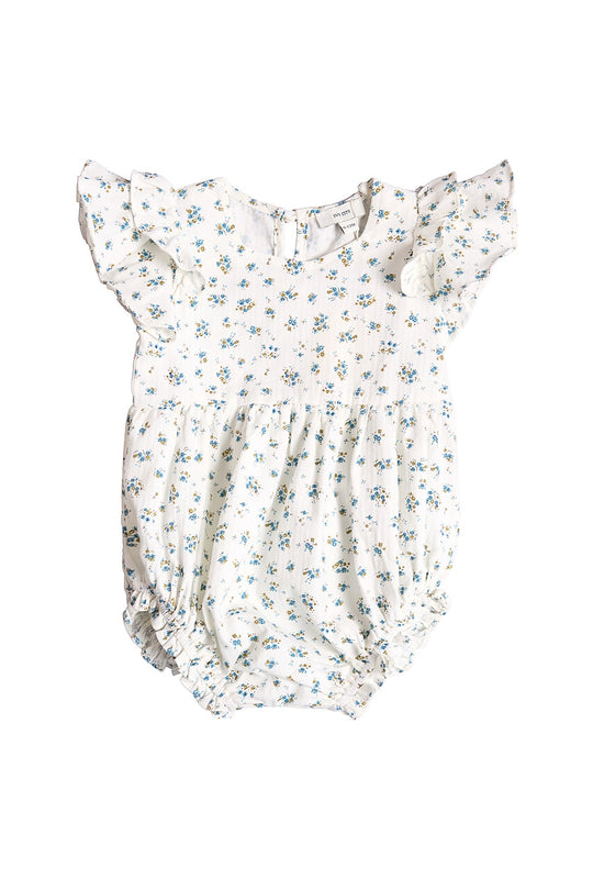 The Ivy City Co Baby Hattie Romper in Madeline Blue is an adorable white cotton baby romper adorned with a delicate blue floral print. It features short ruffle sleeves, a gathered waist, and elastic leg openings for comfort. Perfect as a special occasion baby outfit, this romper includes a classic button closure at the back and is shown on a white background.