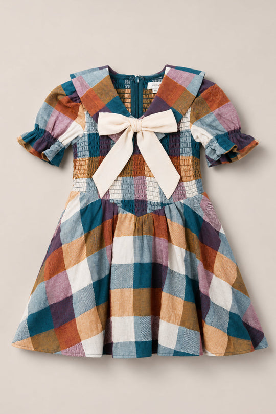 The Mini Alice Dress in Maize Gingham by Ivy City Co is a vibrant gingham dress for young children, featuring charming puff sleeves, a beautifully smocked bodice, a large cream-colored bow at the neckline, and a wide sailor-style collar in a matching gingham pattern.