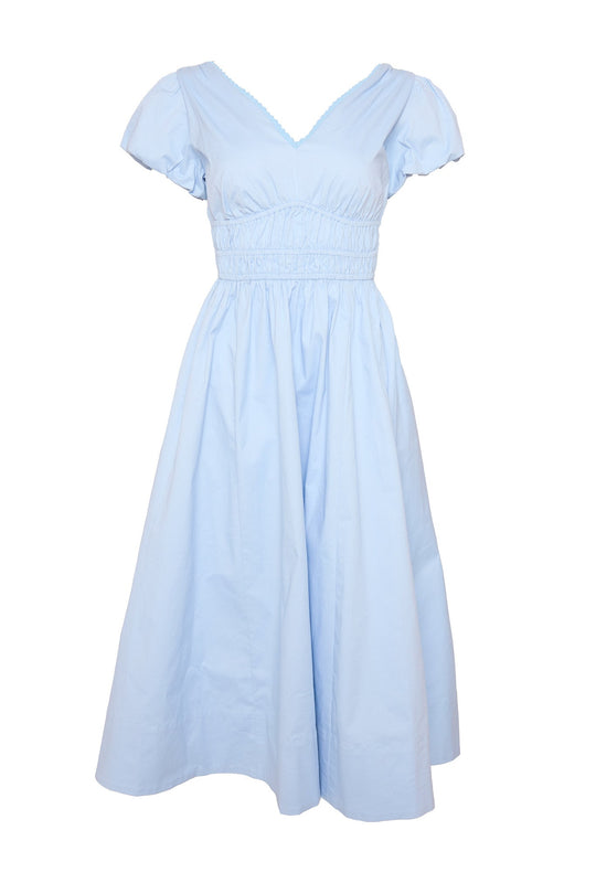The Zella Dress in Sky Blue by Ivy City Co features a light blue hue, short sleeves, a knee-length midi cut, and a V-neckline. Designed with a fitted smocked waist and flared skirt, this dress is crafted from lightweight fabric that’s gently gathered at the waist and sleeves. The style has no visible patterns or accessories for a clean look.