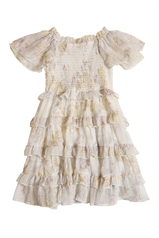 Introducing the Mini Winnie Dress in Bright White Wispy Wildflower by Ivy City Co—a short-sleeved girls’ dress featuring a soft, delicate wildflower print, airy ruffled layers, and a smocked bodice for an elegant touch.