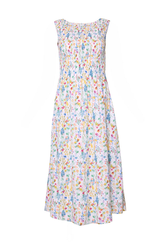 The Ana Dress in Floral Fields by Ivy City Co features a sleeveless design with a colorful white floral print, a comfortable smocked bodice, and a flared midi-length skirt. Designed with a round neckline and lightweight fabric, this dress offers a summery look that is also maternity friendly.