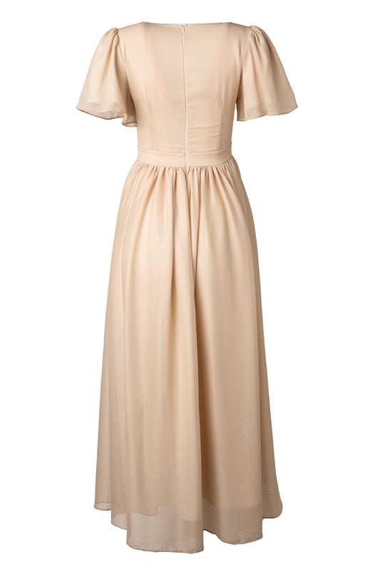 The Abbie Dress in Champagne by Ivy City Co is a champagne maxi with a fitted waist, short puff sleeves, back zipper, and flowing sheer skirt—an elegant choice for bridal parties or evening events.