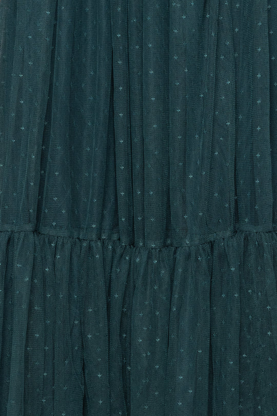 Close-up of a teal dress with a subtle pattern