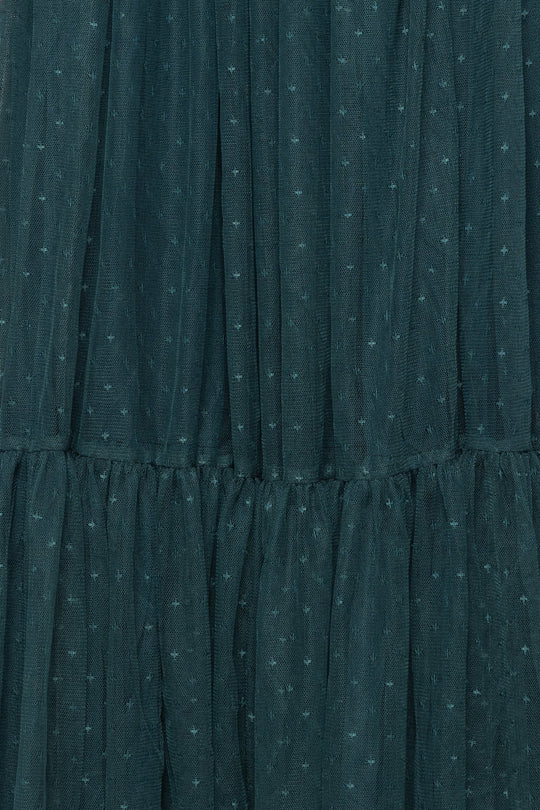 Close-up of dark green sheer fabric with a gathered, tiered design and small dotted textured pattern, reminiscent of the elegant detailing found on the Ivy City Co Adara Dress in Green.
