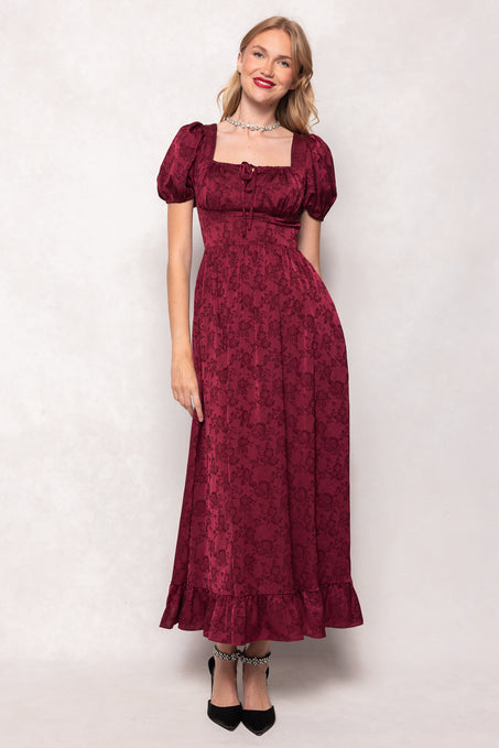 Woman wearing a burgundy floral dress against a white background