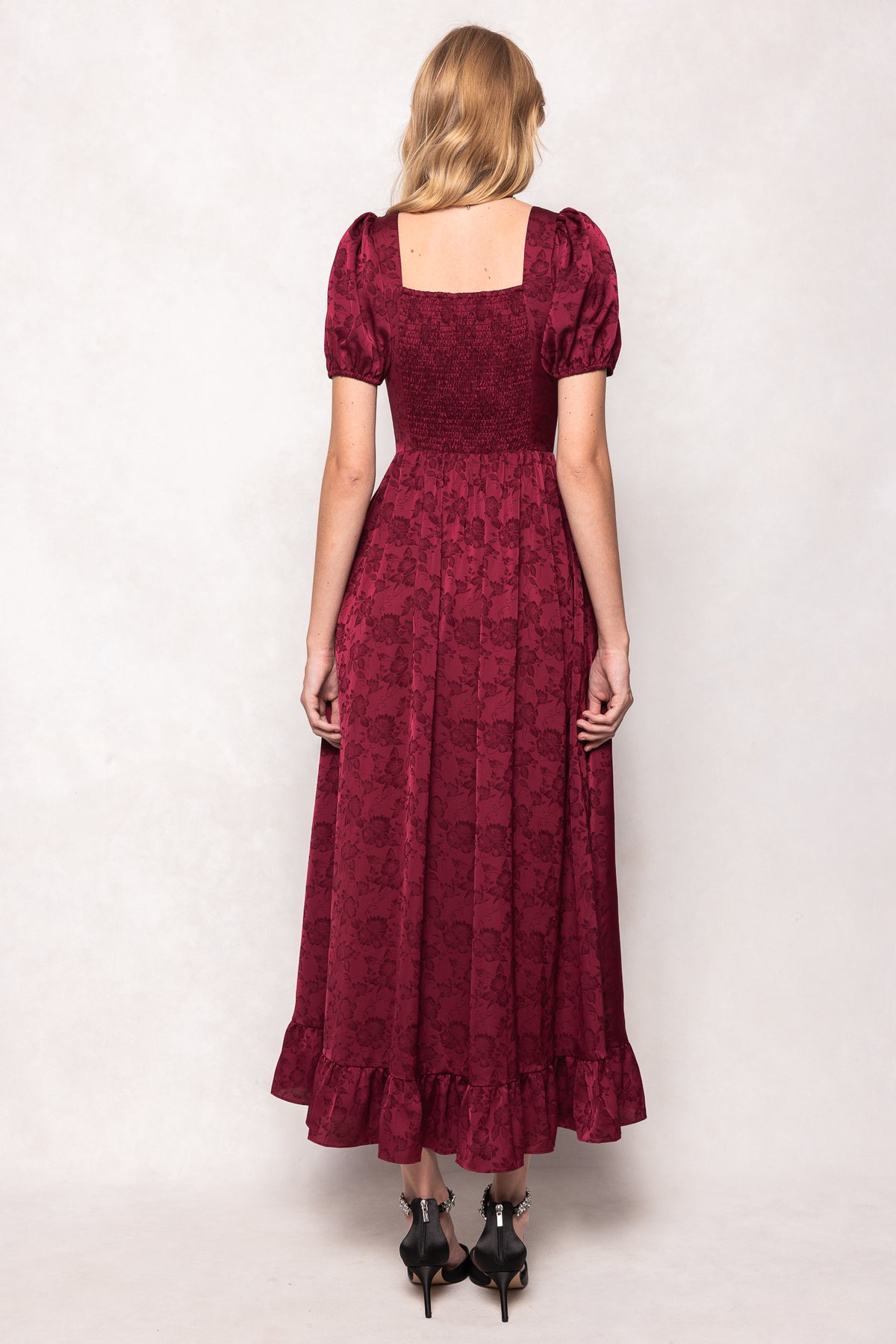 Woman wearing a burgundy lace dress against a white background