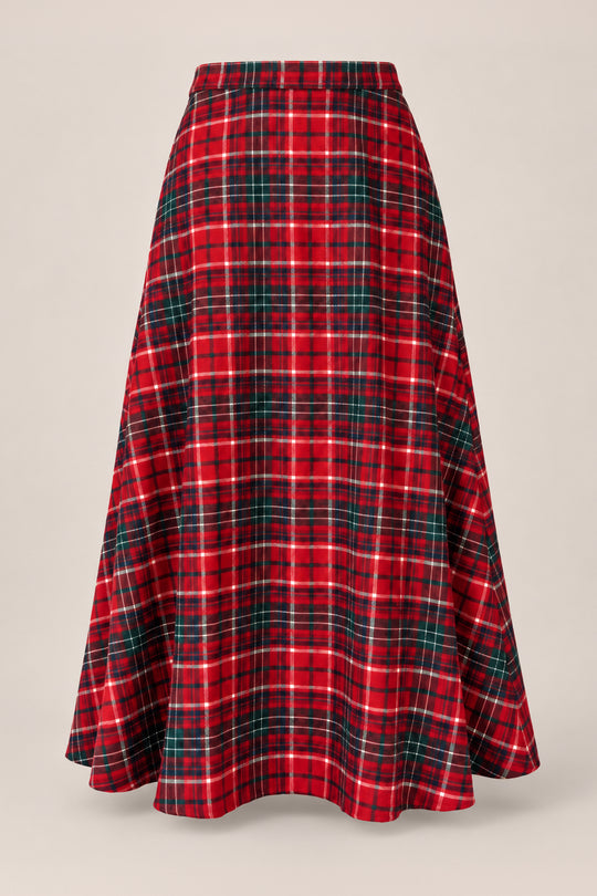 The Ana Skirt in Christmas Cheer Plaid by Ivy City Co, featuring a long, flared silhouette and a festive red, green, and white plaid pattern, is displayed on a plain light beige background.