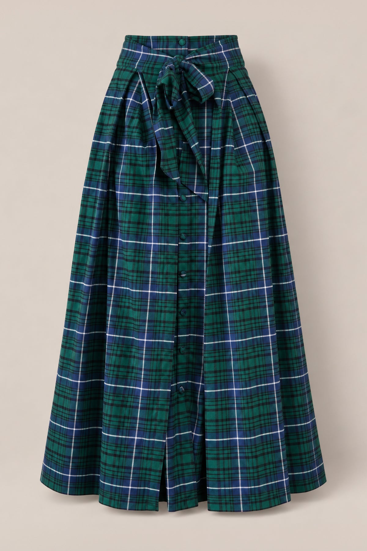 The Angela Skirt in Emerald Plaid by Ivy City Co, crafted from soft cotton with buttons down the front and a matching waist tie, is displayed on a neutral background—making it perfect for girls’ holiday portraits.