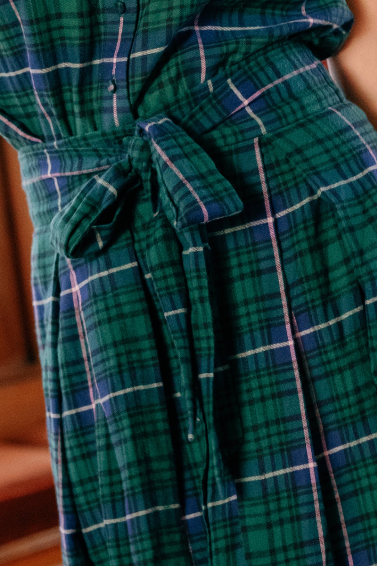 Close-up of the Angela Skirt in Emerald Plaid by Ivy City Co, featuring a green and blue plaid pattern accented with thin white and pink lines. The skirt is styled with a tied belt around the waist, making it perfect for holiday portraits.