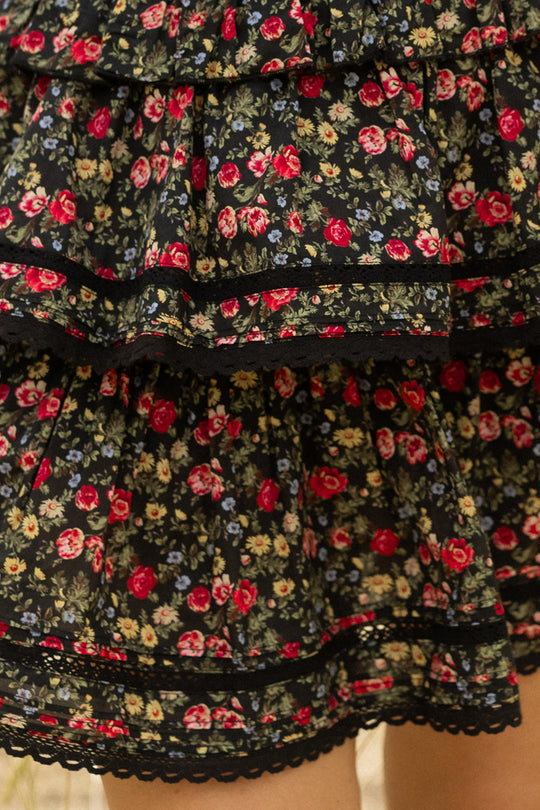 Close-up of the Annalise Skirt in Obsidian Vintage Poppies by Ivy City Co, a cotton skirt with layered ruffles, black lace trim, and a black background adorned with red, yellow, and blue vintage poppies.