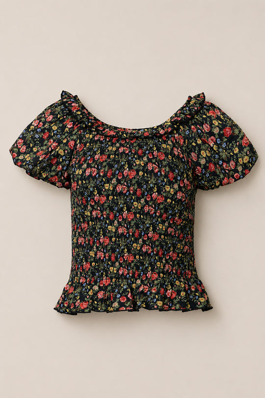 The Annalise Top in Obsidian Vintage Poppies by Ivy City Co is a black, short-sleeved floral top with puff sleeves, a ruffled neckline and hem, red, yellow, and pink flowers, plus a chic smocked bodice.