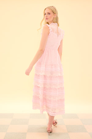 Woman wearing a pink dress against a light yellow background