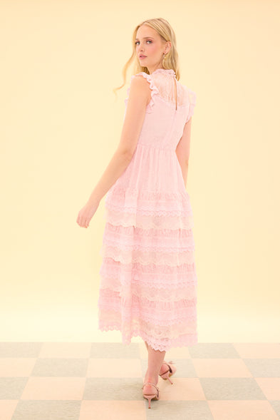 Woman wearing a pink dress against a light yellow background