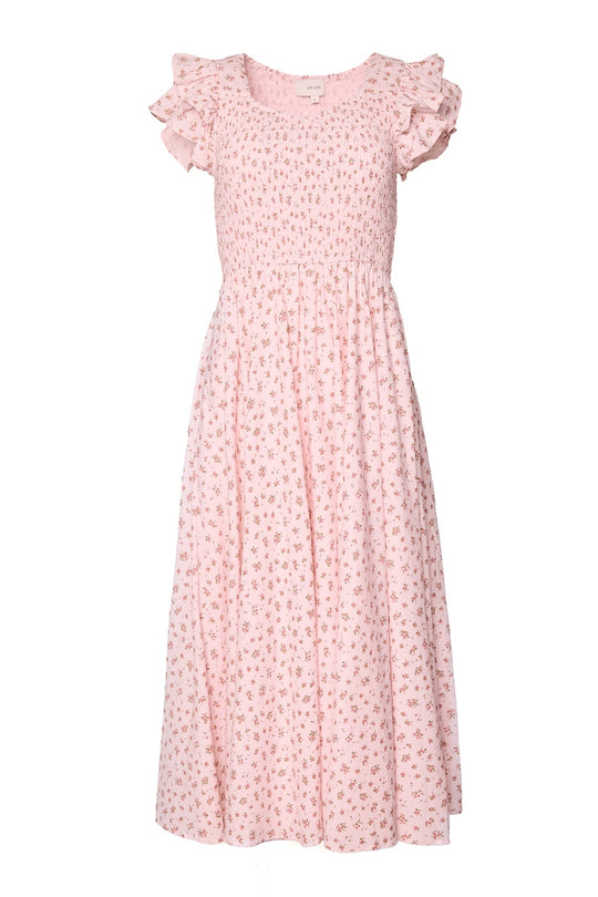 The Hattie Dress in Madeline Pink by Ivy City Co is a light pink cotton midi dress featuring short sleeves, ruffled shoulders, and a smocked bodice with a delicate all-over small floral print. Its loose, flowy skirt offers a soft, feminine silhouette—an ideal choice for birthday celebrations or any special occasion.