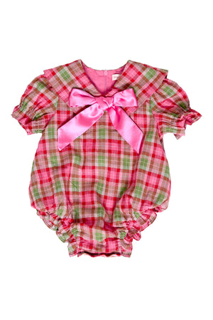 Pink and green plaid baby romper with a large bow on a white background