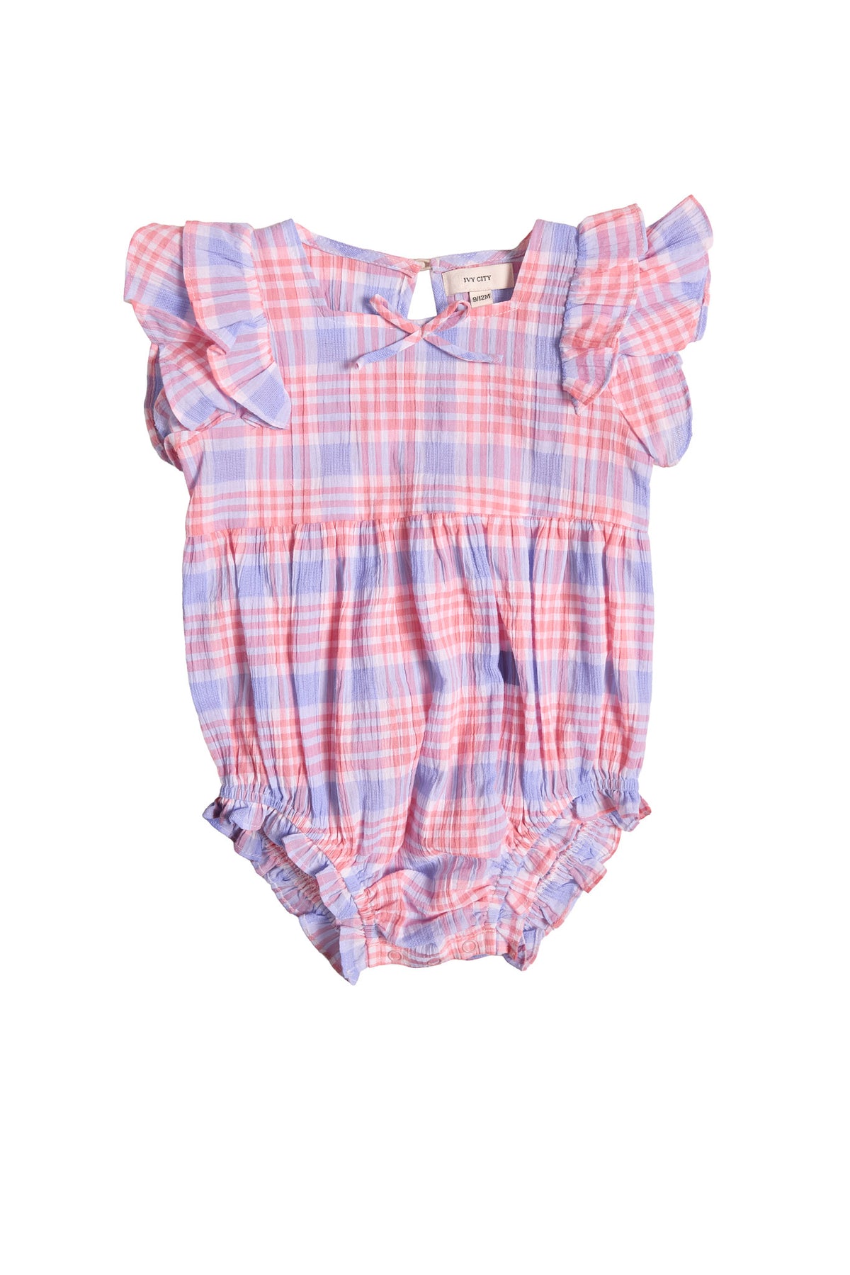 The Baby Ana Romper in Blossom Plaid by Ivy City Co features pink, purple, and white plaid, short ruffled sleeves, a gathered waist and legs, and a cute neckline bow—perfect for spring.
