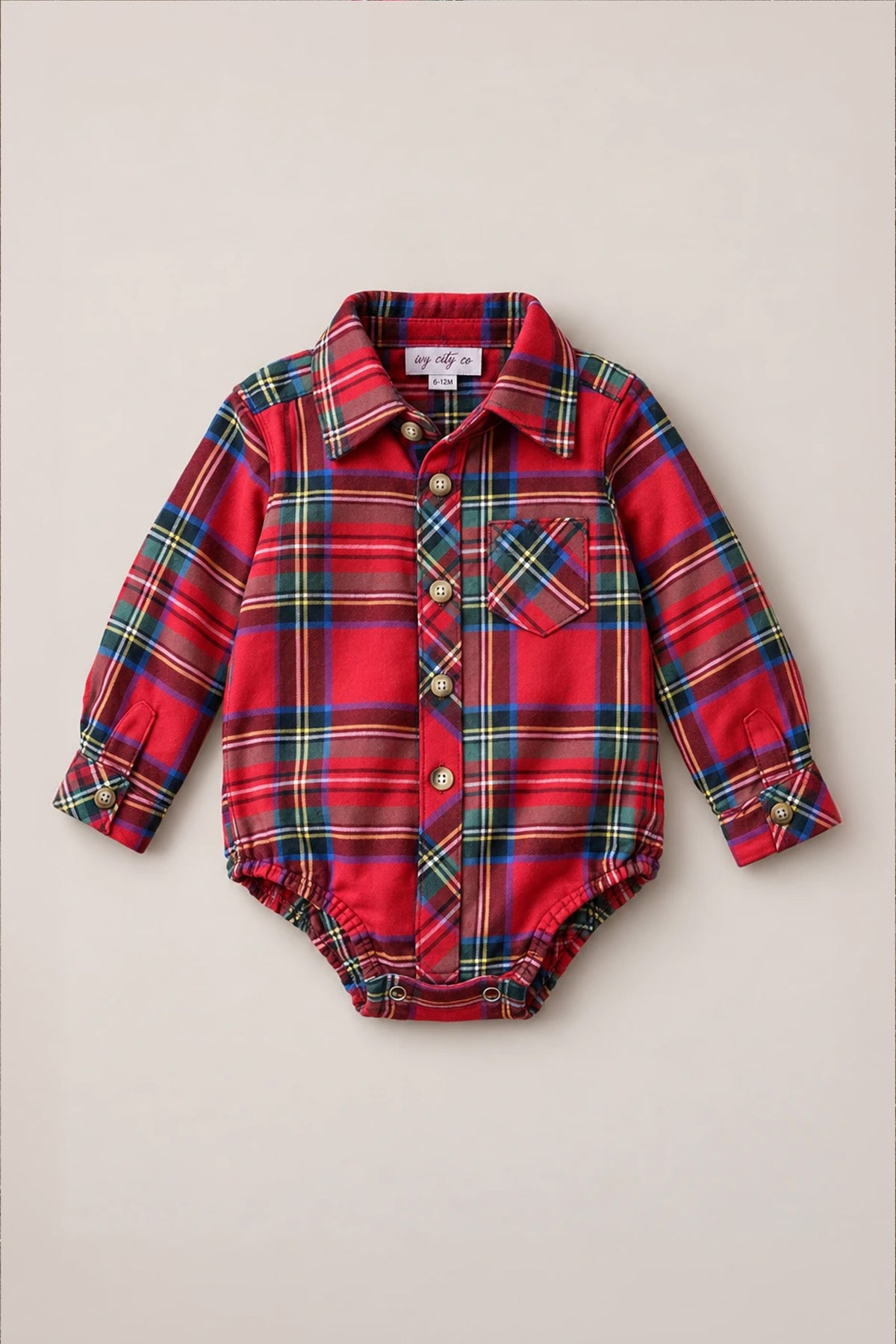 Introducing the Ivy City Co Baby Boys John Romper in Holiday Plaid—a festive red cotton bodysuit designed with a collar, front pocket, and button closures along the front and cuffs. Snap buttons at the bottom make diaper changes a breeze, merging holiday charm with comfortable practicality for your little one.