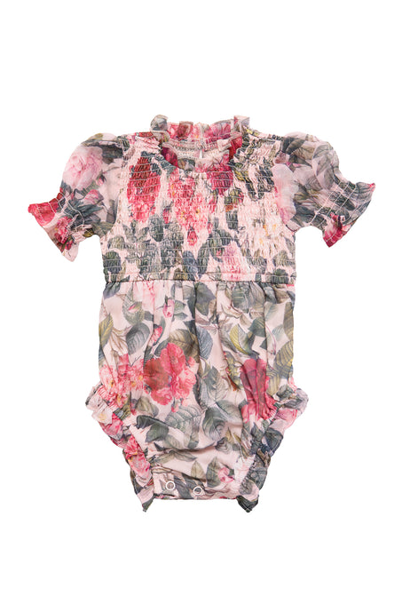 The Ivy City Co Baby Cordelia Romper in Pink Bloom features a floral-patterned design with short sleeves, ruffled neckline, smocked bodice, and convenient diaper snaps accented by pink, red, and green flowers and leaves.