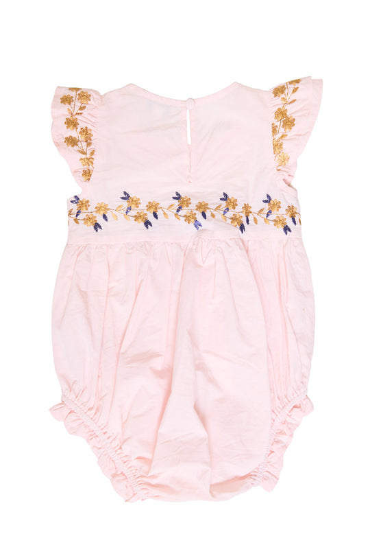 the back of a pink baby romper against a white background