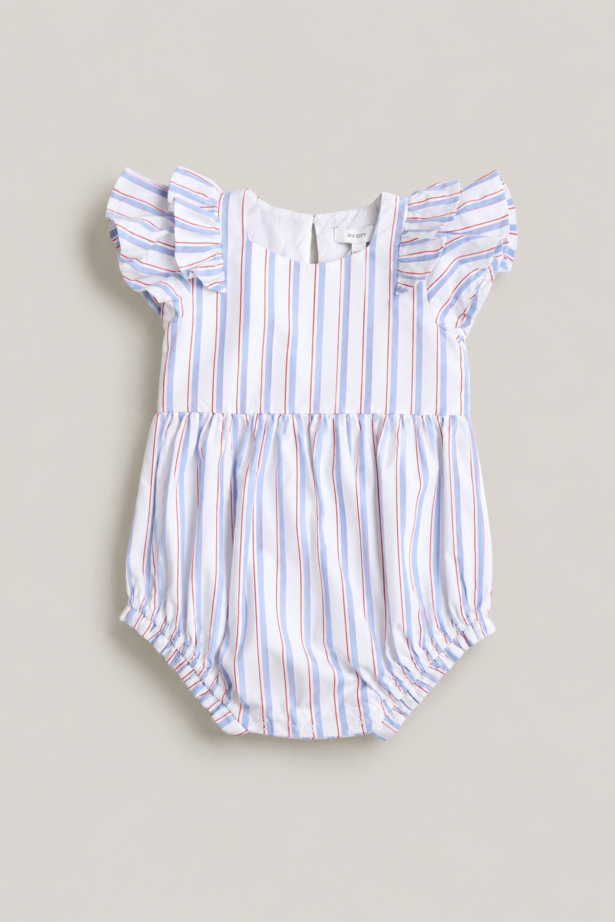 The Ivy City Co Baby Hattie Romper in Heritage Stripe features short ruffled sleeves, gathered leg openings, and blue, red, and white stripes—a perfect Fourth of July outfit for your baby. Shown laid flat on a neutral background.