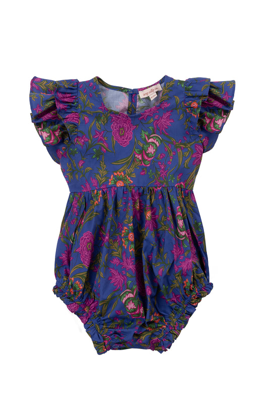 The Ivy City Co Baby Hattie Romper in Blue Multicolor Floral features ruffled short sleeves, elastic leg openings, and a round neckline, with a vibrant pink, green, and purple floral print on soft cotton.