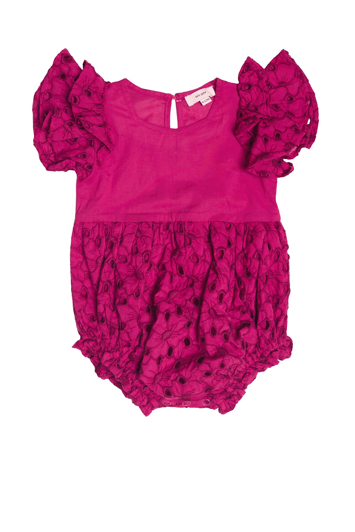 The Baby Hattie Romper in Magenta by Ivy City Co features bright pink embroidered eyelet cotton, puffed sleeves with floral texture, a round neckline, and back button closure—perfect for Easter outfits.