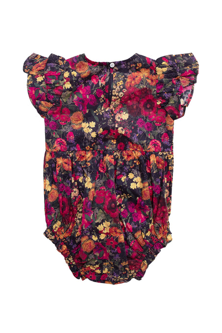 The Baby Hattie Romper in Night Garden by Ivy City Co features flutter sleeves, a dark floral print with red, yellow, and orange blooms, gathered leg openings, and easy diaper snaps—charming and practical for your little one.