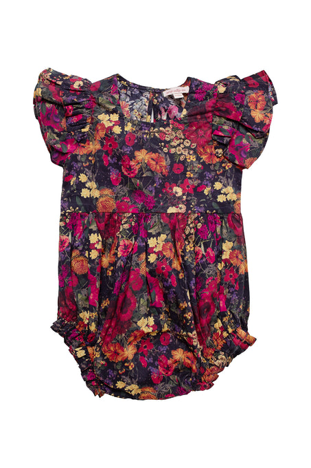 The Ivy City Co Baby Hattie Romper in Night Garden features a colorful red, yellow, orange, and purple floral pattern on a dark background, ruffled short sleeves, and diaper snaps for easy changes.