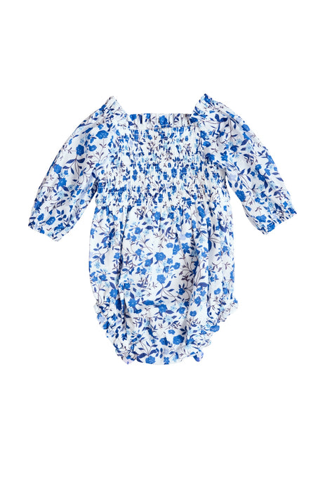 The Ivy City Co Baby Madeline Romper in Ditsy Cobalt Floral features blue and white blooms, long sleeves, an elasticized bodice, ruffled leg openings, and a gathered neckline—perfect for mom and me matching moments.