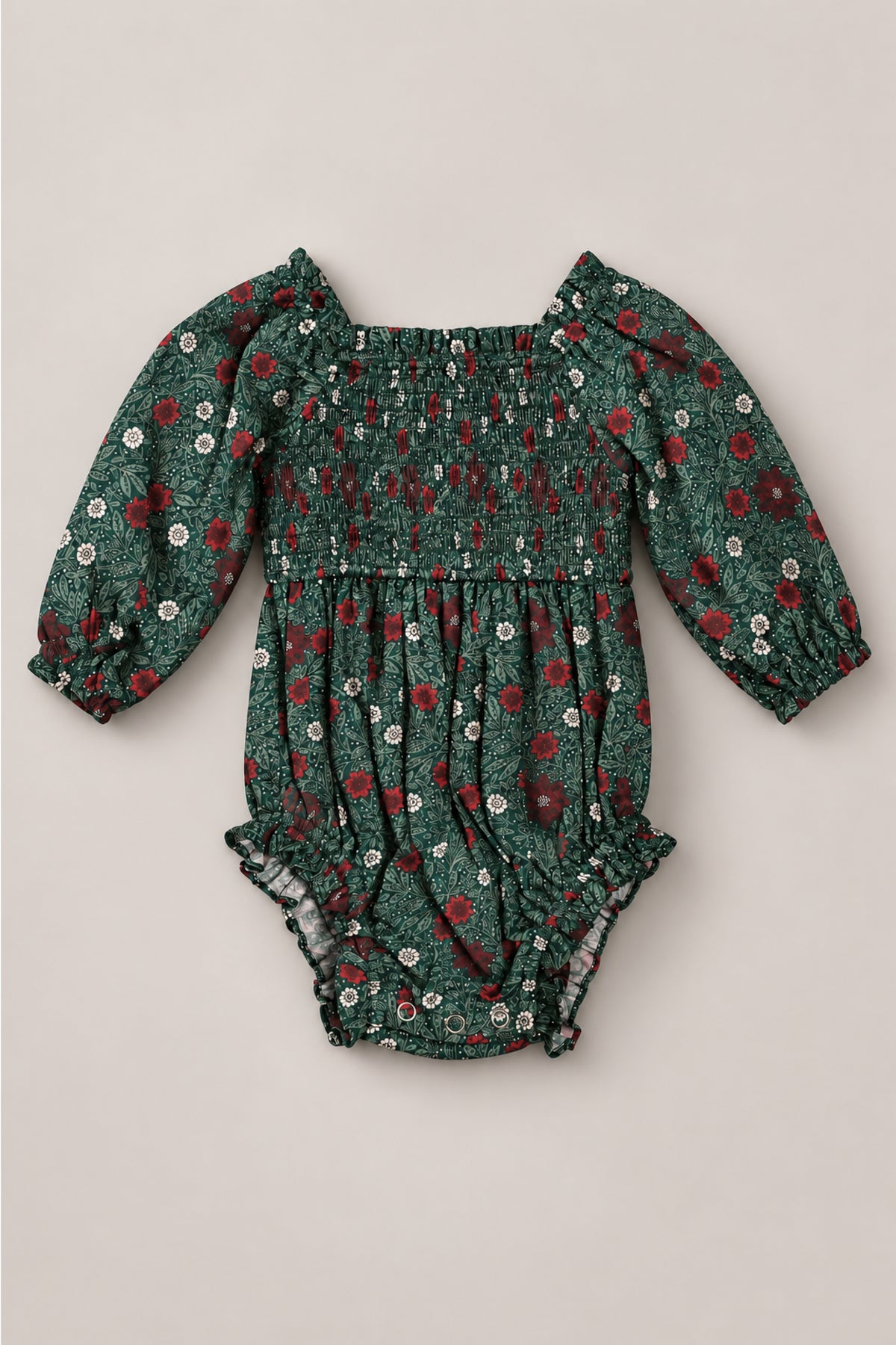 The Baby Madeline Romper in Evergreen Merry Ditsy by Ivy City Co is a charming girls’ Christmas romper for babies, featuring long sleeves, a green fabric with red and white floral print, smocked bodice, elastic cuffs, and ruffled leg openings—all crafted from 100% cotton for festive comfort.