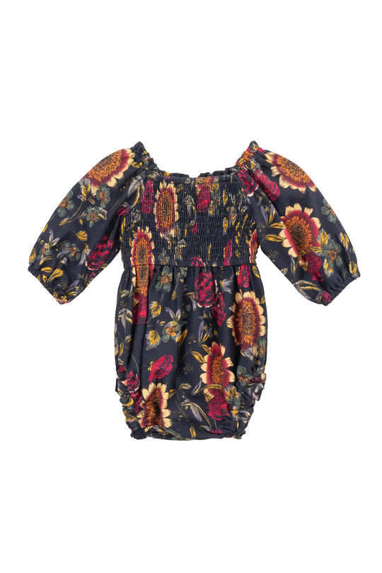 The Ivy City Co Baby Madeline Romper in Moody Sunflower features puffed sleeves, a dark background with red, orange, and yellow sunflower print, and gathered elastic at the waist and sleeves for comfort.
