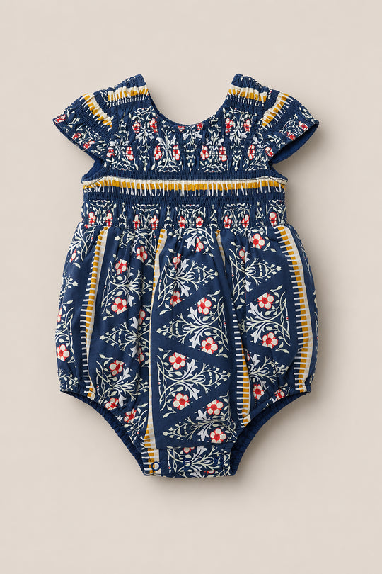 Discover the Baby Marlow Romper in Navy Fleur by Ivy City Co—a delightful short-sleeve cotton romper featuring navy blue, white, yellow, and red floral patterns. This charming piece showcases a classic round neckline and gathered details at both the neckline and waist for added comfort and style.
