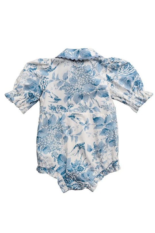 The Ivy City Co Baby Sophia Romper in Blue Floral is an adorable baby romper with blue floral patterns on white fabric, featuring puffed short sleeves, a collar, and elastic leg openings.