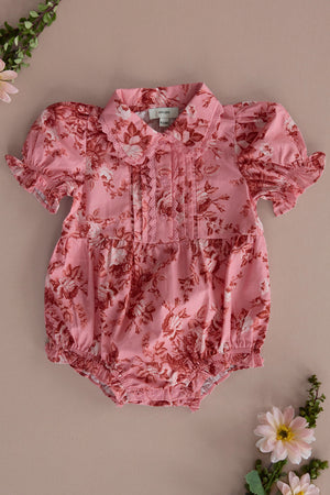 Dress your little one in the Baby Sophia Romper in Desert Heritage Rose by Ivy City Co, featuring pink floral cotton, puffed short sleeves, a Peter Pan collar, front pleats, and snap closures—a sweet Easter outfit.