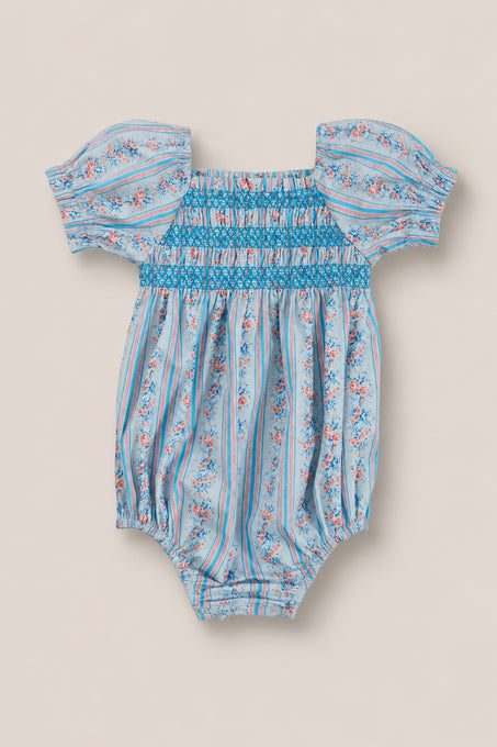 The Ivy City Co Baby Sunday Best Romper in Rosette Linear Stripe features blue, pink, and white stripes with floral accents, puff sleeves, a smocked chest, elastic legs—ideal for adorable mom and me matching outfits.