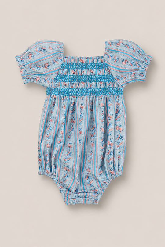 The Ivy City Co Baby Sunday Best Romper in Rosette Linear Stripe features blue, pink, and white stripes with floral accents, puff sleeves, a smocked chest, elastic legs—ideal for adorable mom and me matching outfits.