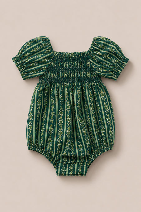 The Ivy City Co Baby Sunday Best Romper in Pine Felicity Floral features short puffed sleeves, a smocked chest, and vertical floral stripes on a beige background.