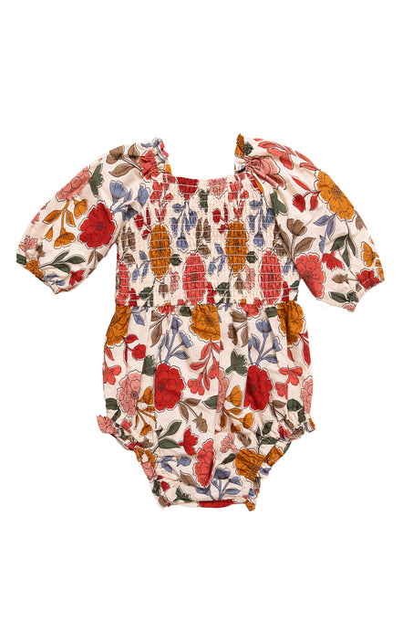 The Ivy City Co Baby Teagan Romper in Sepia Flower features a smocked bodice, puffed long sleeves, and diaper snaps, accented by a charming floral print in red, orange, and mustard on a white background.