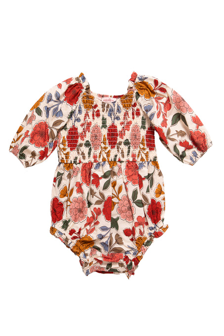 The Ivy City Co Baby Teagan Romper in Sepia Flower features a smocked bodice, elasticized leg openings, diaper snaps for easy changes, and a vibrant red, orange, and blue floral print on white.