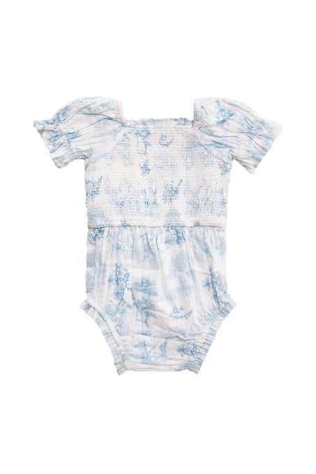The Ivy City Co Baby Valencia Romper features light blue and white cotton, puff sleeves, a smocked bodice, and a delicate floral toile print, shown against a plain white background.
