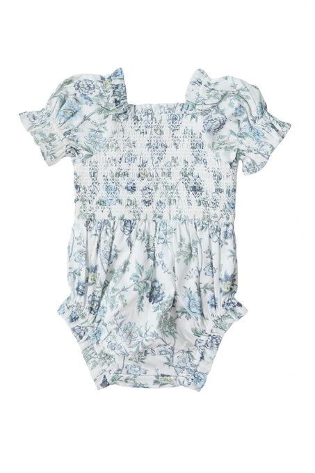 The Baby Valencia Romper in Ivory Climbing Vine Bloom by Ivy City Co features short puff sleeves, a smocked bodice, and a blue and green floral pattern on white, crafted from 100% cotton for comfort.