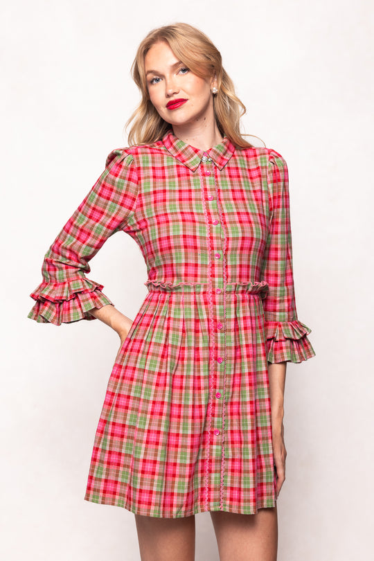 Woman wearing a red and green plaid dress on a white background