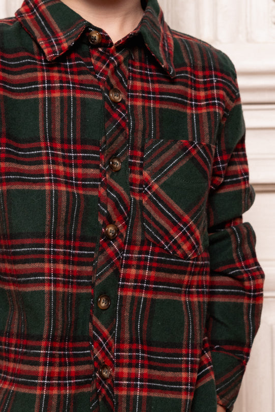 Close-up of a green and red plaid shirt with buttons.