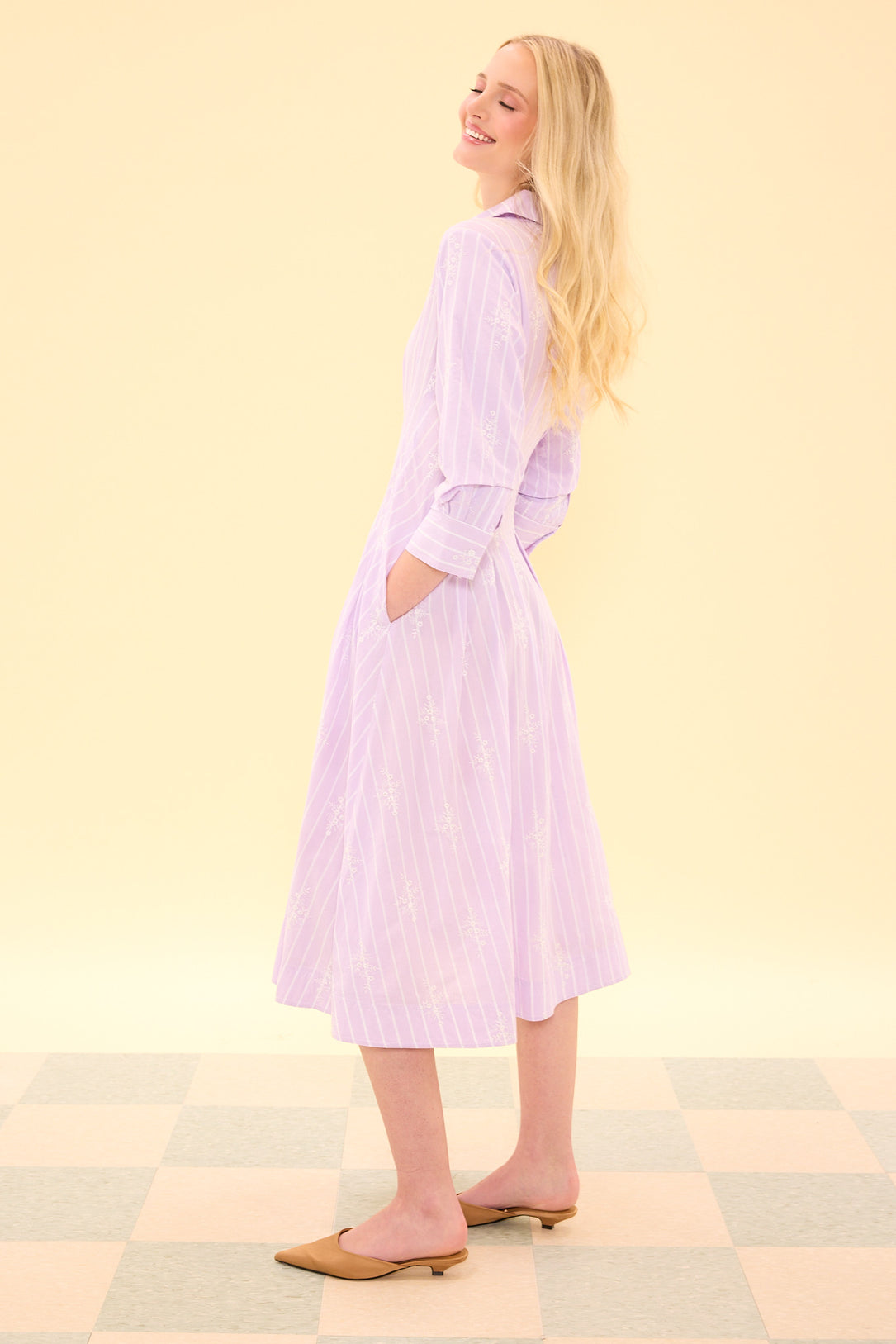 Woman wearing a light purple dress with a yellow background