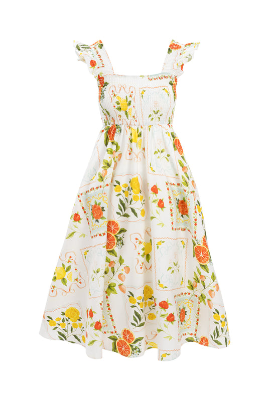 The Camilla Dress in Citrus by Ivy City Co is a sleeveless cotton midi with ruffle straps, a smocked bodice, and a full skirt featuring an orange and lemon citrus print with yellow and orange flowers for a fresh summer look.